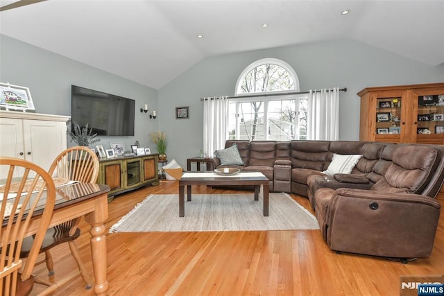 living area with vaulted ceiling and light wood finished floors