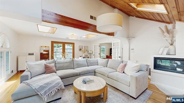 living area featuring french doors, light wood-type flooring, visible vents, wood ceiling, and lofted ceiling with skylight