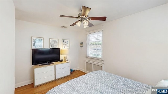 bedroom with ceiling fan, baseboards, visible vents, and light wood-style flooring