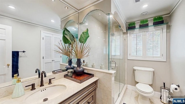 bathroom featuring a stall shower, vanity, baseboards, toilet, and ornamental molding