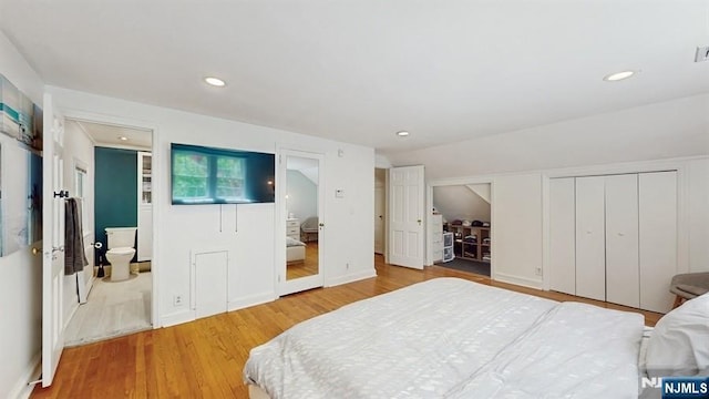 bedroom featuring recessed lighting, multiple closets, and wood finished floors
