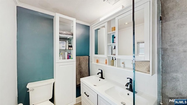 full bathroom with crown molding, toilet, a sink, and double vanity
