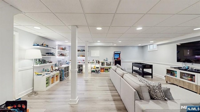 living area featuring baseboards, a drop ceiling, recessed lighting, and light wood-style flooring