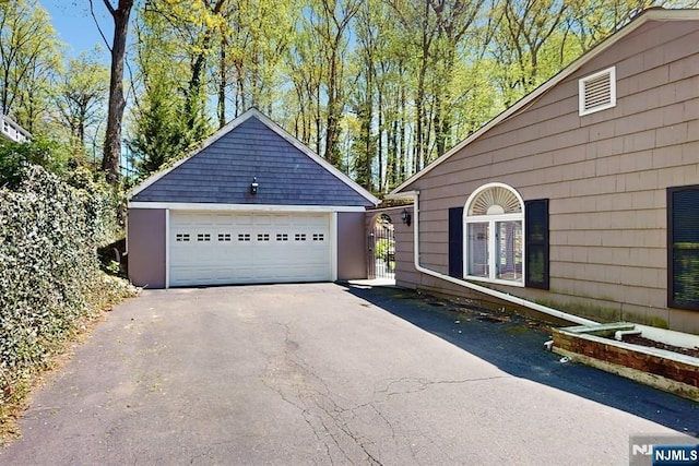 view of property exterior featuring a detached garage and an outdoor structure