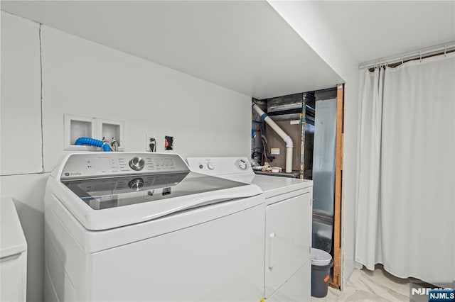 laundry area featuring washer and clothes dryer and marble finish floor