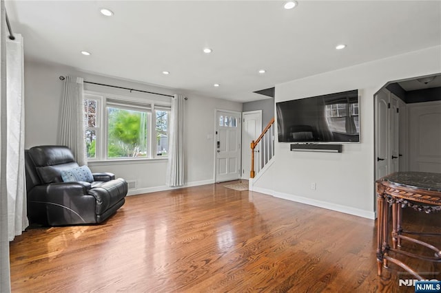 living area with visible vents, baseboards, recessed lighting, wood finished floors, and stairs
