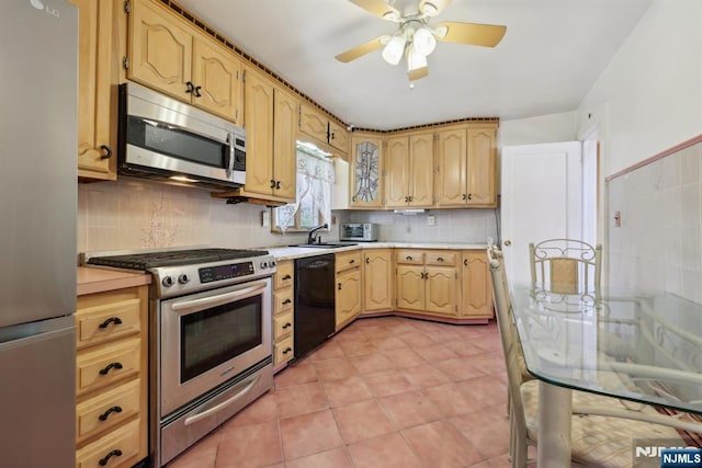 kitchen with appliances with stainless steel finishes, ceiling fan, tasteful backsplash, and light countertops