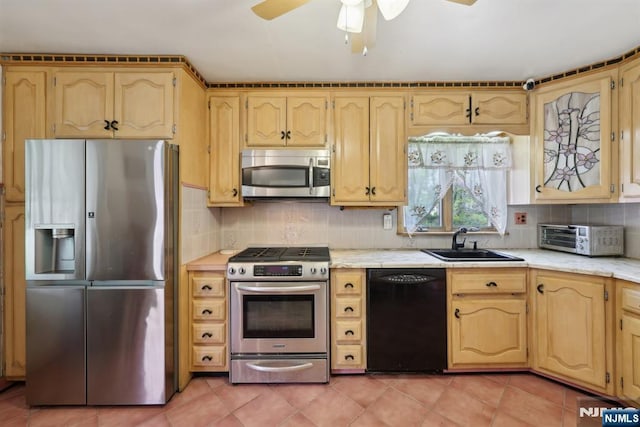 kitchen with a toaster, a sink, appliances with stainless steel finishes, and light countertops