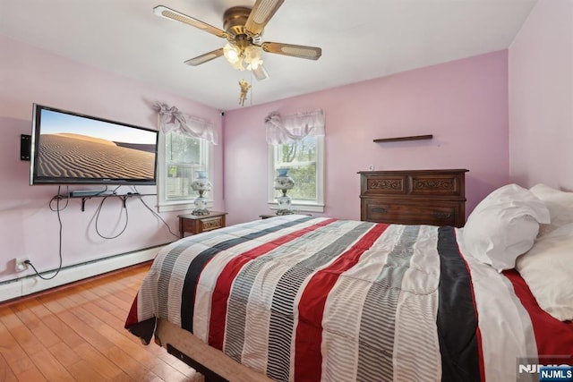 bedroom featuring a ceiling fan, hardwood / wood-style floors, and a baseboard heating unit