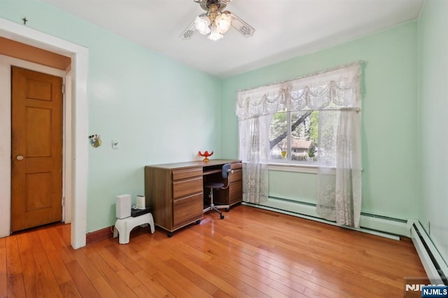 office featuring baseboards, a ceiling fan, baseboard heating, and light wood-style floors
