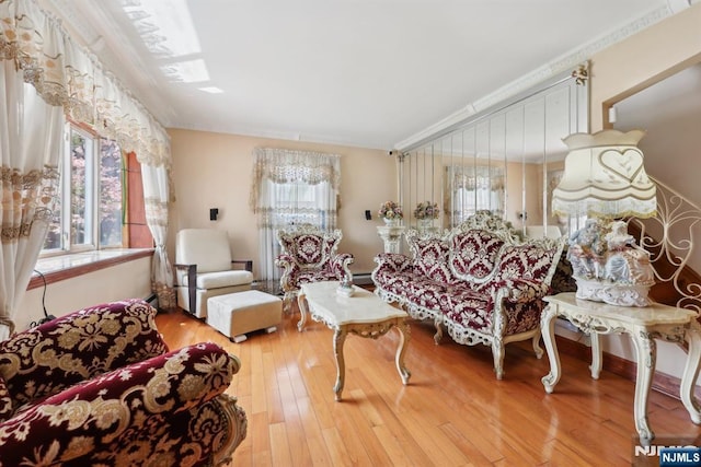 living area with crown molding and hardwood / wood-style floors