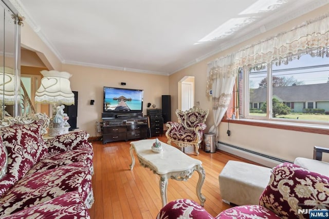 living room with a baseboard heating unit, wood-type flooring, and crown molding