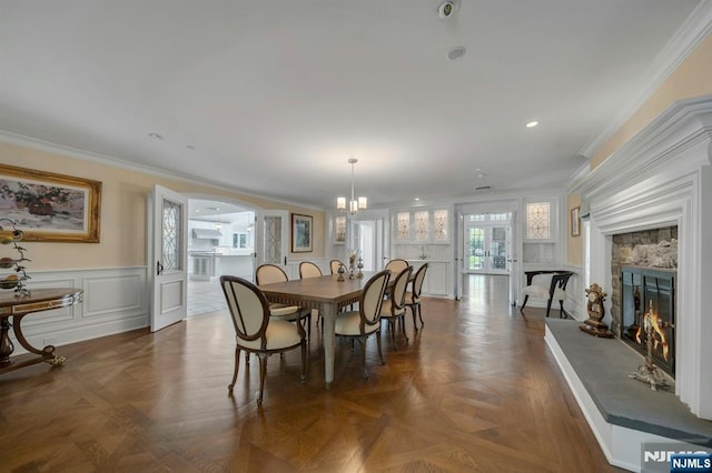 21 Birchwood, Old Tappan, NJ 07675 - dining room with a stone fireplace, a chandelier, a decorative wall, a wainscoted wall, and ornamental molding