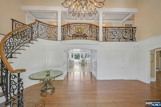21 Birchwood, Old Tappan, NJ 07675 - entrance foyer with arched walkways, a high ceiling, a chandelier, wood finished floors, and stairs