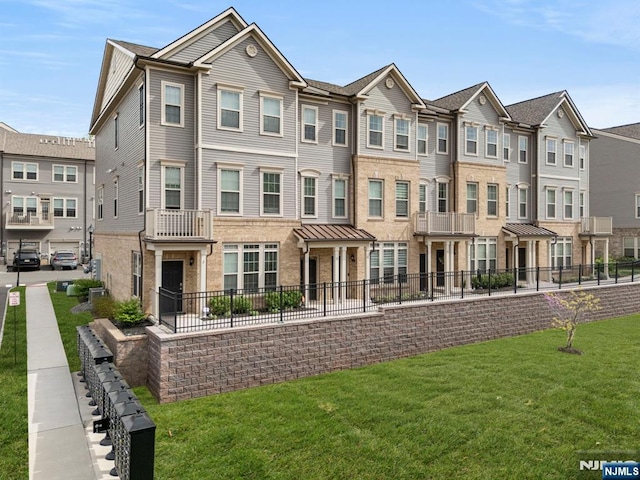 4 Arnold Dr, Wood Ridge, NJ 07075 - townhome / multi-family property with brick siding, fence, a residential view, and a front lawn