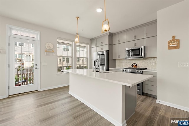 4 Arnold Dr, Wood Ridge, NJ 07075 - kitchen with gray cabinets, backsplash, light countertops, light wood-style floors, and stainless steel appliances