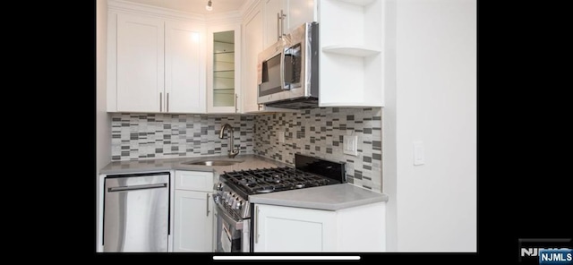 kitchen featuring a sink, decorative backsplash, appliances with stainless steel finishes, and light countertops