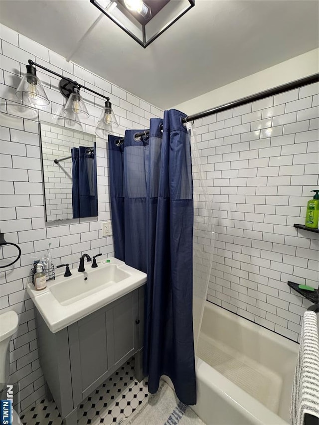 full bath featuring toilet, tile walls, shower / bathtub combination with curtain, a sink, and backsplash