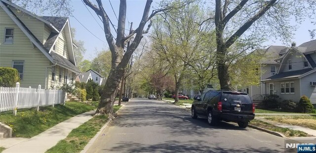 view of street with curbs, sidewalks, and a residential view