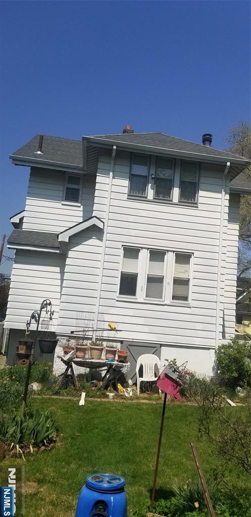 rear view of house featuring a lawn
