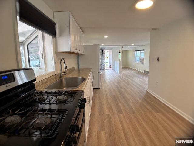 46 Park Dr, Oakland, NJ 07436 - kitchen with baseboards, white cabinetry, stainless steel range with gas stovetop, a sink, and light wood finished floors