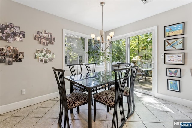 dining area featuring light tile patterned flooring, baseboards, an inviting chandelier, and a wealth of natural light