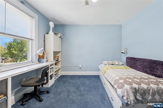 bedroom featuring dark carpet and baseboards