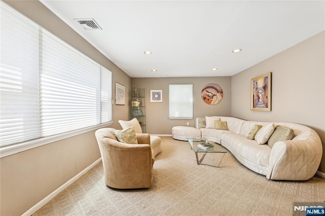 carpeted living area featuring recessed lighting, baseboards, and visible vents
