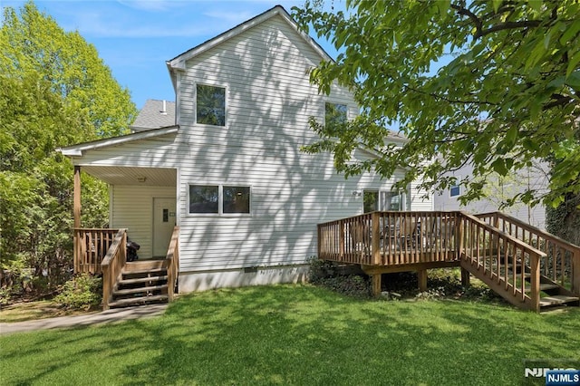 rear view of property with a yard, a wooden deck, and stairs