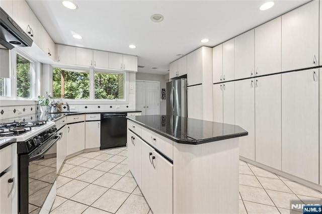 kitchen featuring range with gas cooktop, backsplash, light tile patterned floors, freestanding refrigerator, and black dishwasher