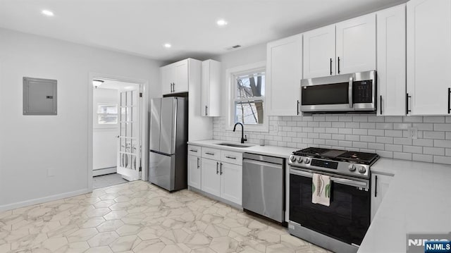 kitchen with a sink, light countertops, electric panel, and stainless steel appliances
