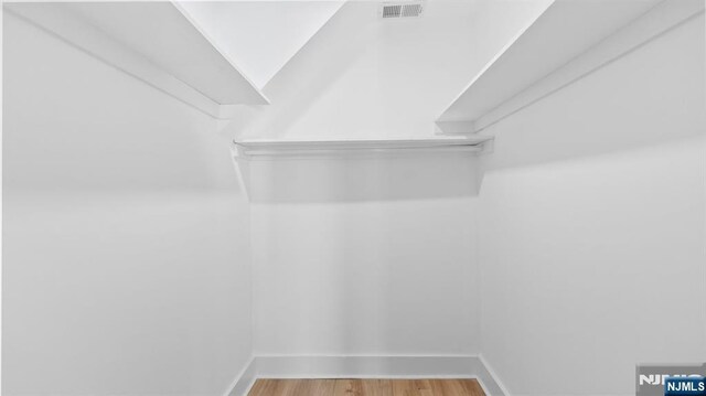 spacious closet with wood finished floors and visible vents