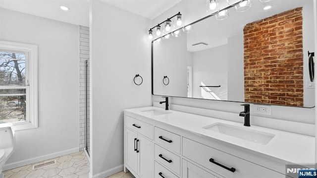 full bathroom with a sink, baseboards, toilet, and visible vents