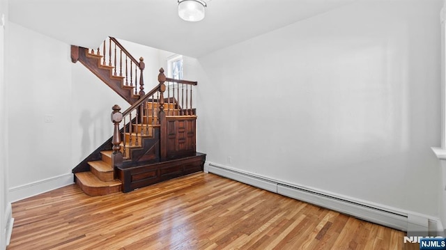 interior space featuring baseboards, a baseboard heating unit, and wood finished floors