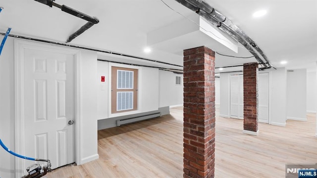 finished basement featuring baseboards, recessed lighting, wood finished floors, and baseboard heating