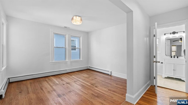 spare room featuring baseboards, visible vents, and wood finished floors