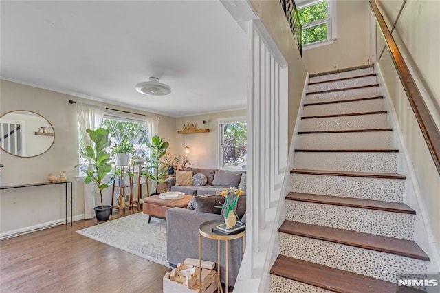 stairs with baseboards, ornamental molding, and wood finished floors