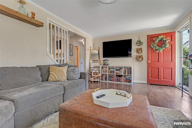 living room with baseboards, ornamental molding, and wood finished floors