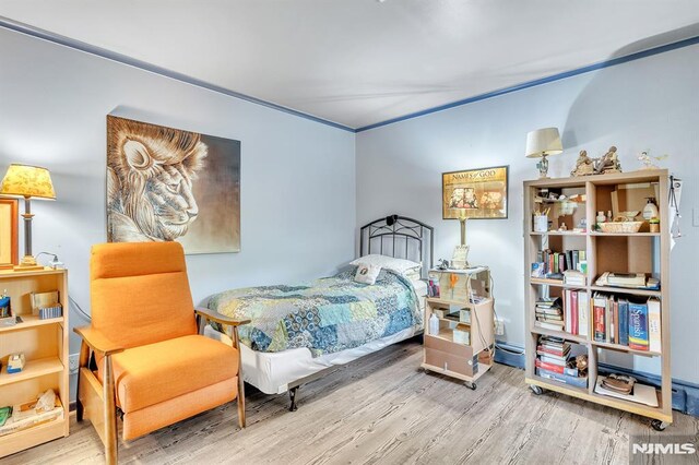 bedroom with wood finished floors and baseboard heating
