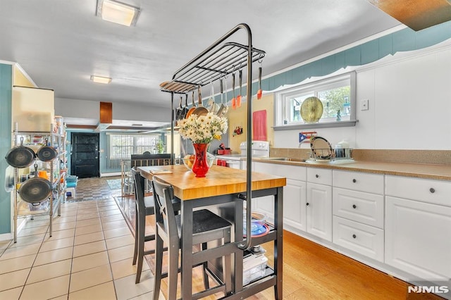 kitchen featuring a sink, washer / clothes dryer, and white cabinetry