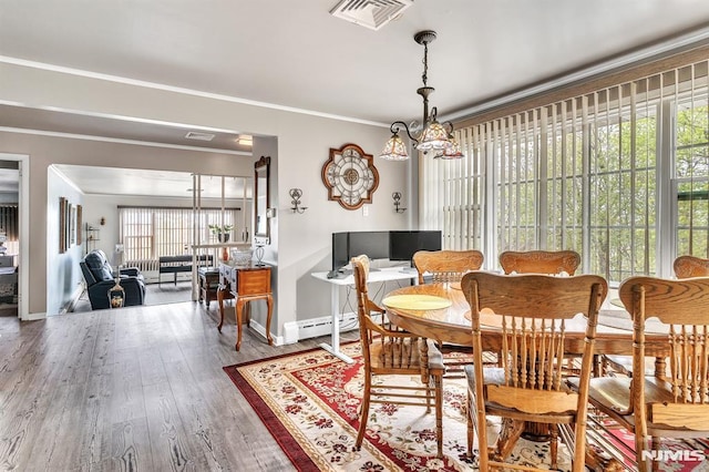 dining area featuring visible vents, crown molding, an inviting chandelier, wood finished floors, and baseboards