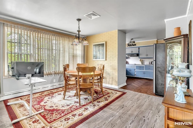 dining room featuring baseboards, a baseboard heating unit, and visible vents