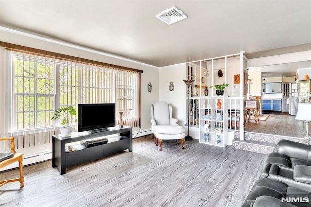 living room featuring a baseboard radiator, wood finished floors, and visible vents