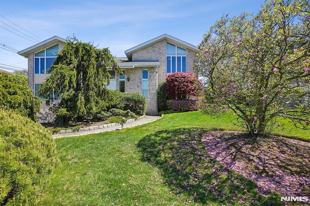 view of front of house with brick siding and a front lawn