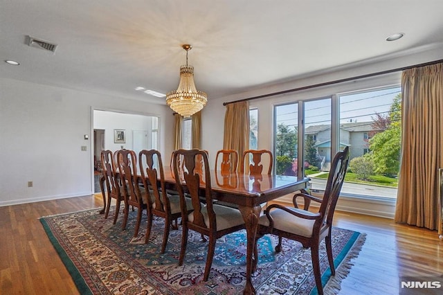 dining room with visible vents, wood finished floors, baseboards, a notable chandelier, and recessed lighting