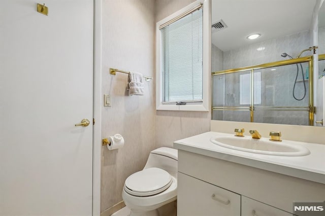 full bathroom with visible vents, a stall shower, toilet, and vanity