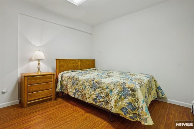 bedroom featuring baseboards and wood finished floors