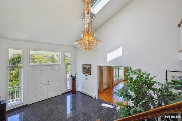 foyer featuring a baseboard radiator, high vaulted ceiling, a healthy amount of sunlight, and a skylight