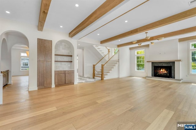 229 Bogert Pl, Paramus, NJ 07652 - unfurnished living room with arched walkways, baseboards, and light wood finished floors