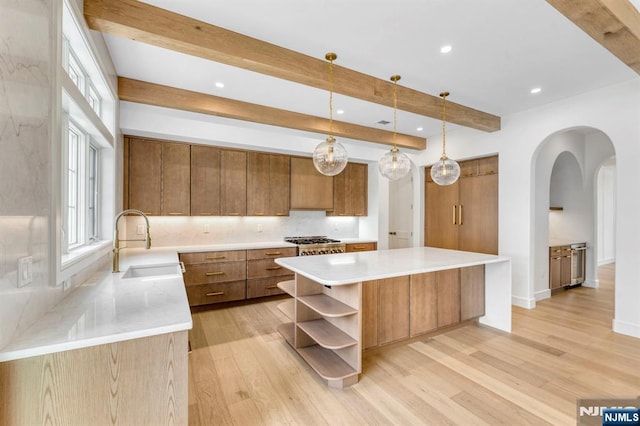 229 Bogert Pl, Paramus, NJ 07652 - kitchen featuring brown cabinetry, arched walkways, open shelves, a sink, and beamed ceiling